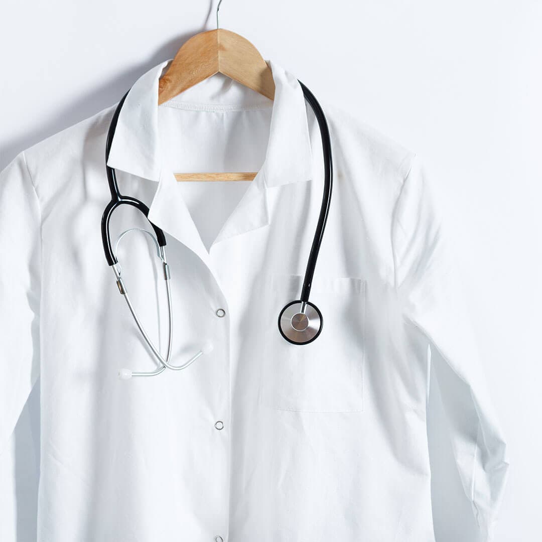 A picture of a white coat on a white background with a stethoscope hanging from it