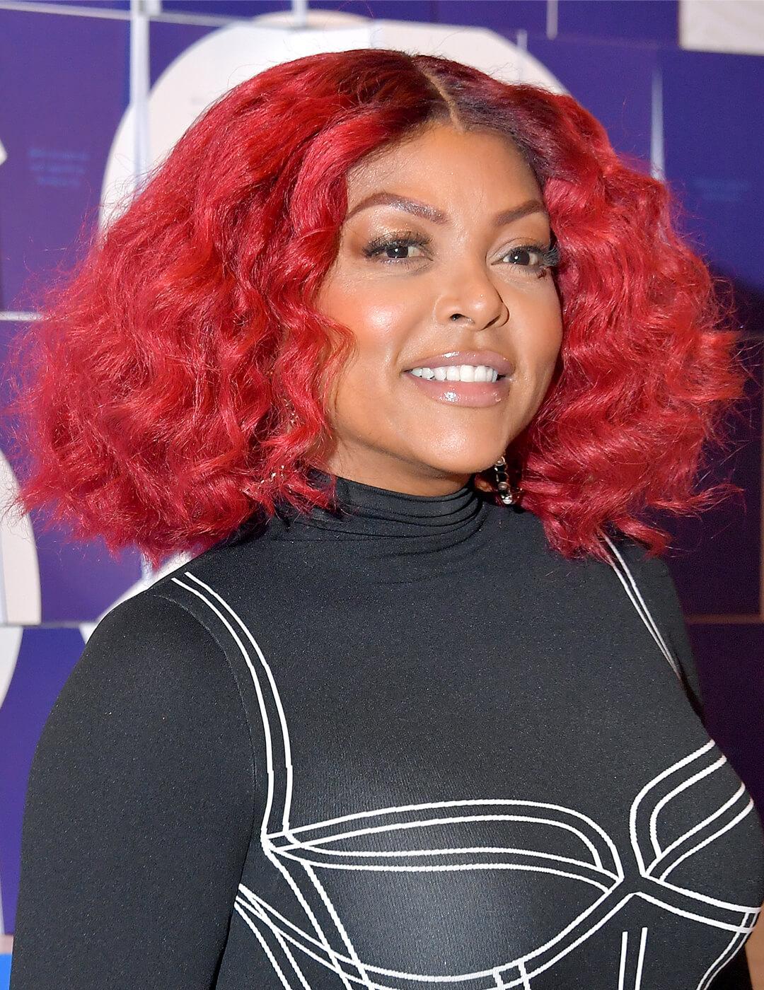 Taraji P. Henson looking bold in a graphic black and white outfit and red, middle-part curly hairstyle