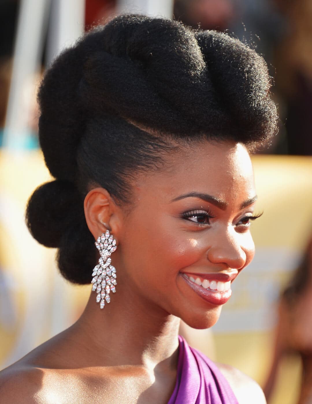 Close-up of Teyonah Parris looking glamorous with a classic up-do hairstyle and dangling diamond earrings