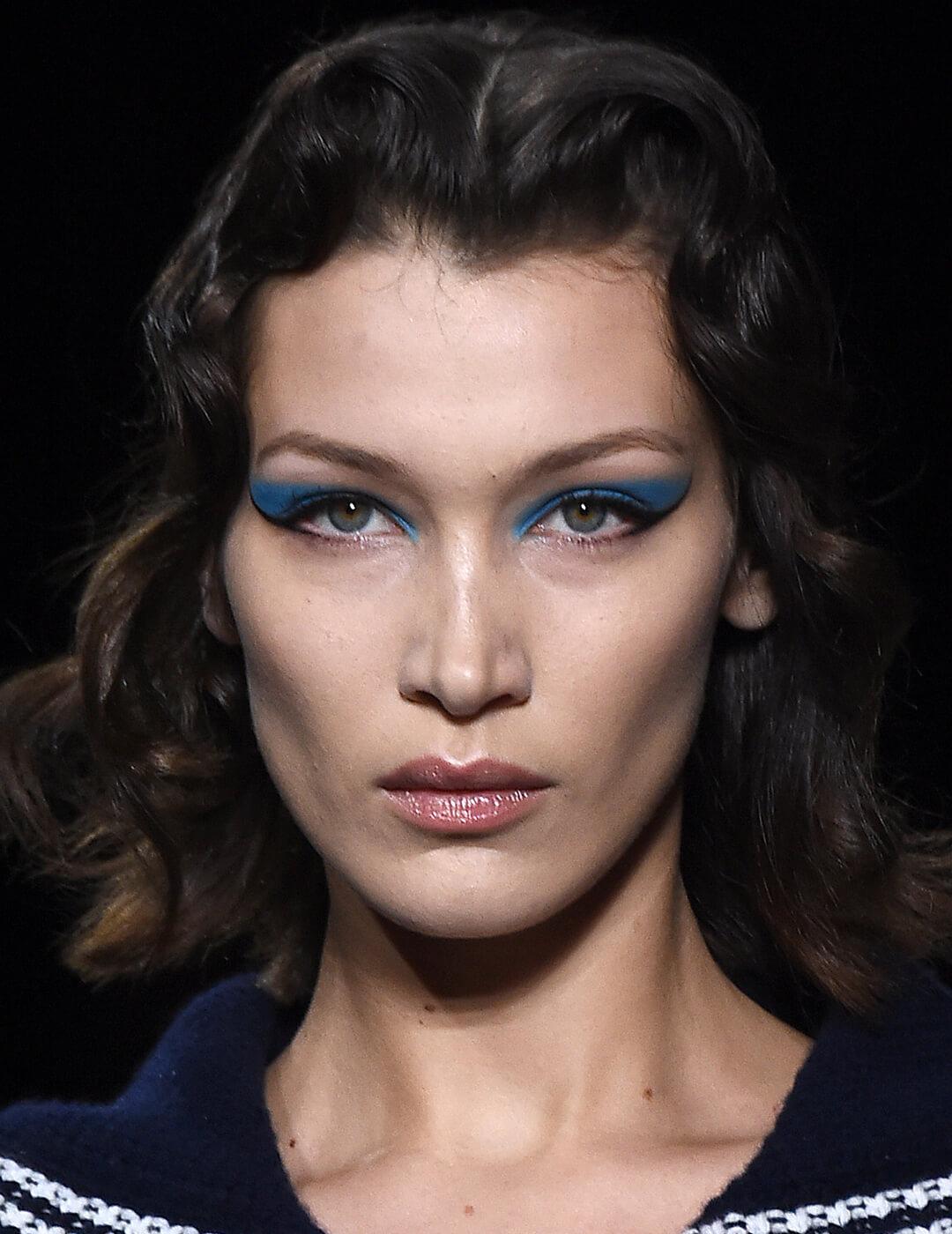 Close-up of Bella Hadid's blue eyeshadow and black winged eyeliner makeup look on the runway