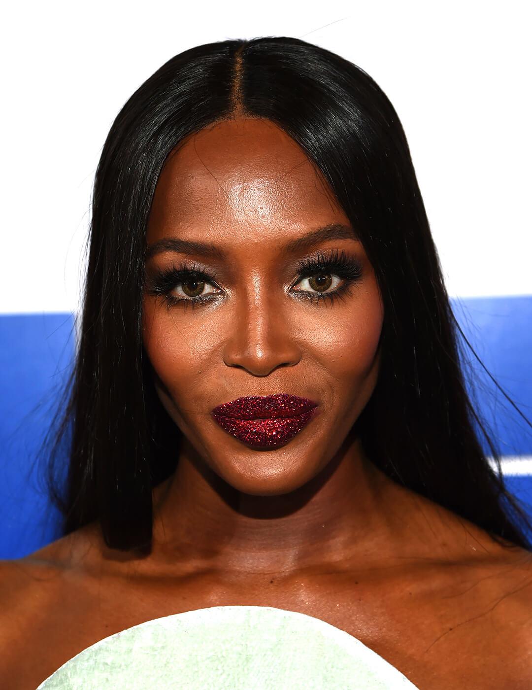 Close-up of Naomi Campbell rocking a smoky eye makeup look paired with glittery dark red lips
