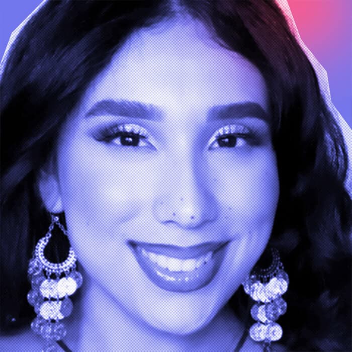 Close-up of a smiling Eloisa Gonzalez Duarte rocking a neutral makeup look and boho dangling earrings