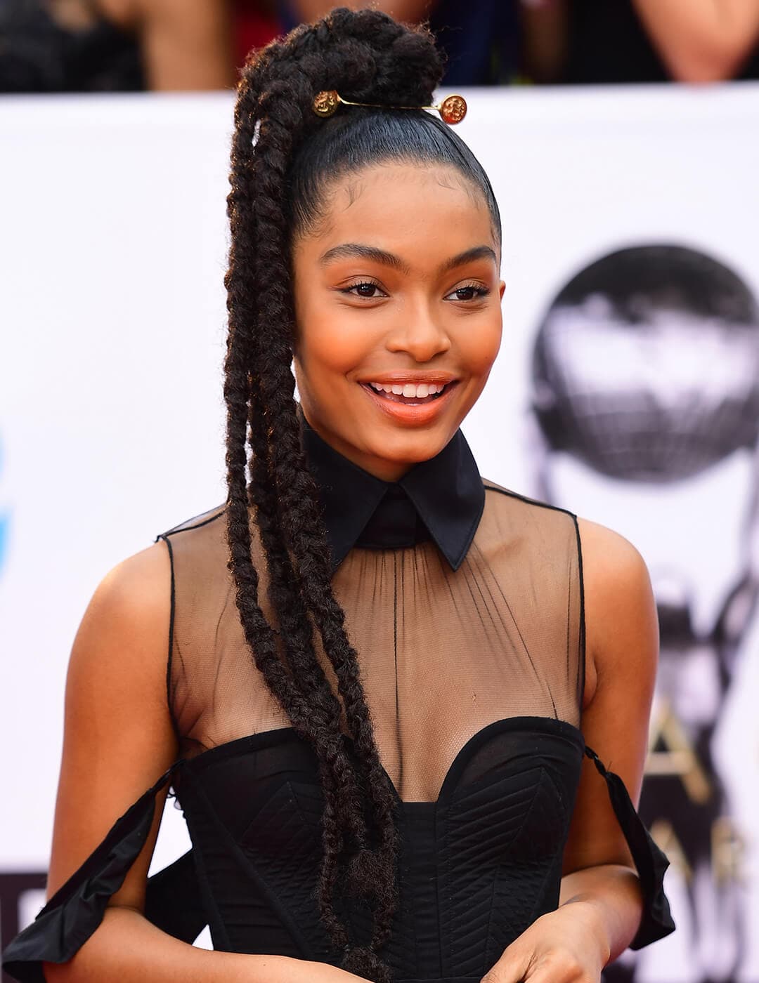 Yara Shahidi rocking a jumbo braided ponytail hairstyle and party sheer black dress