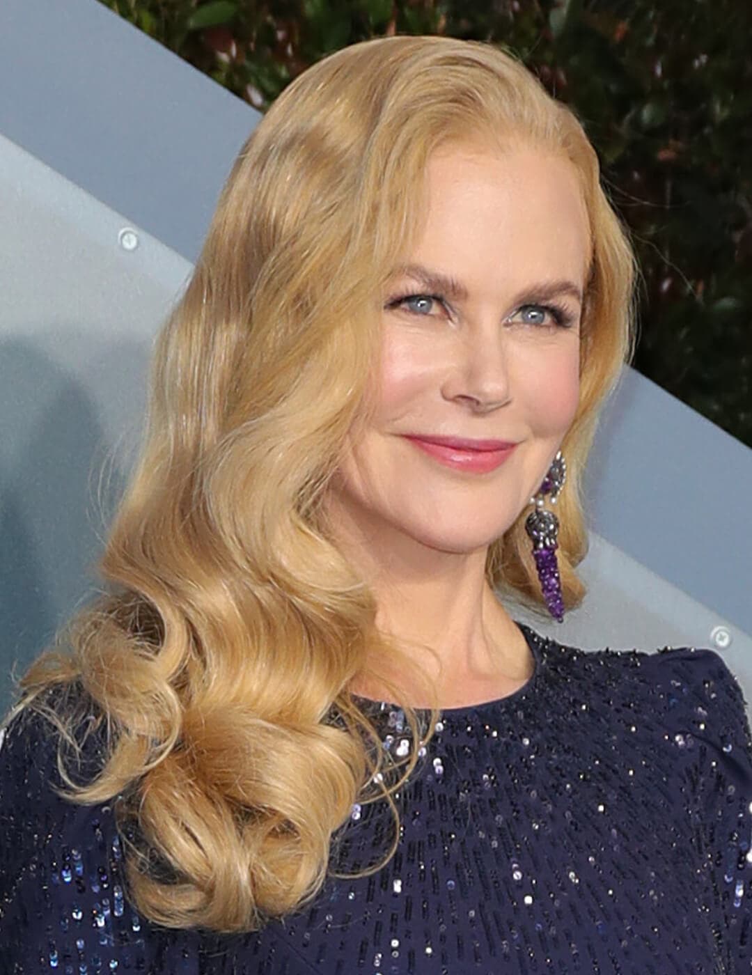 Close-up image of Nicole Kidman in a dark blue glittery rocking a long curly hairstyle