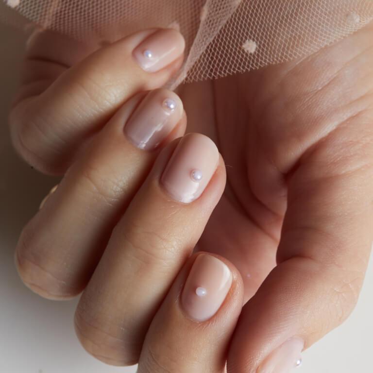 An image of a nude pink nail mani with pearl accents