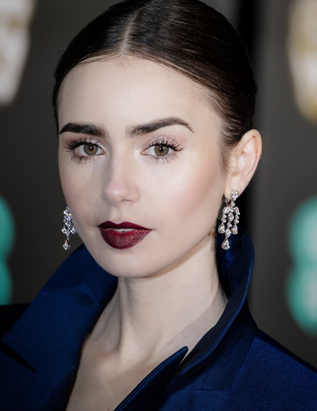 Close-up of Lily Collins rocking shimmery eye makeup and burgundy lips