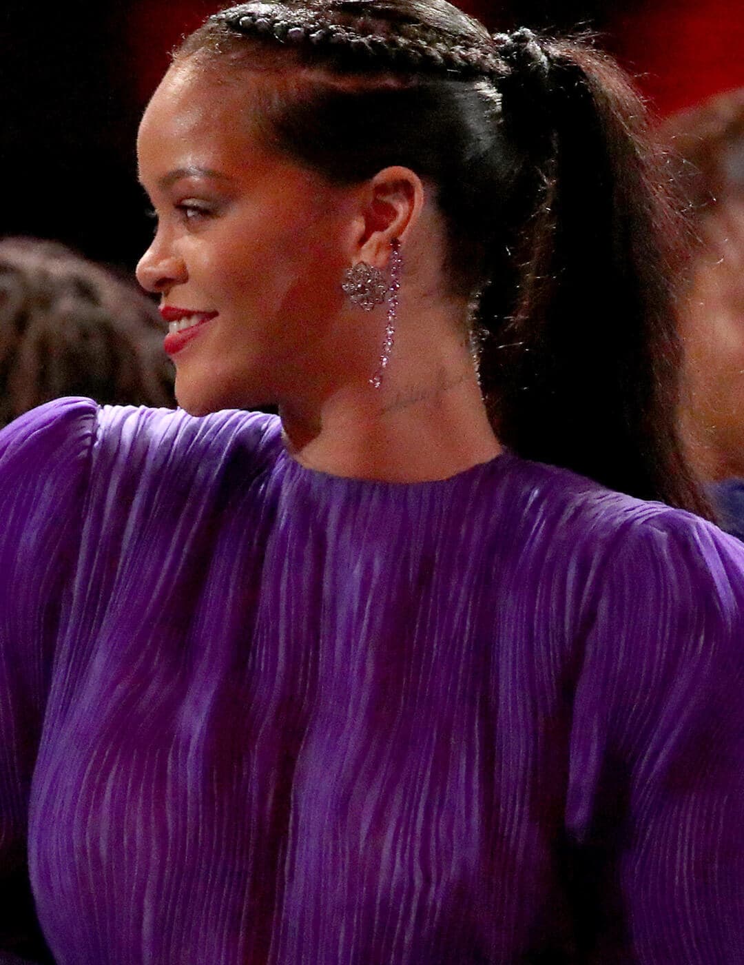 Rihanna rocking a single side brand ponytail hairstyle and purple pleated dress