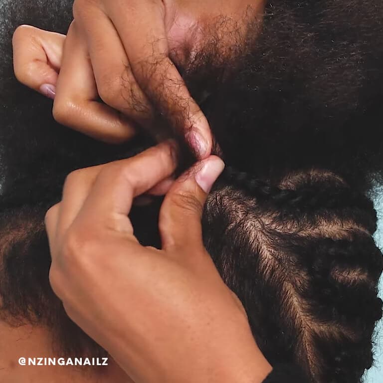 A close-up of a hairstylist creating cornrows. 
