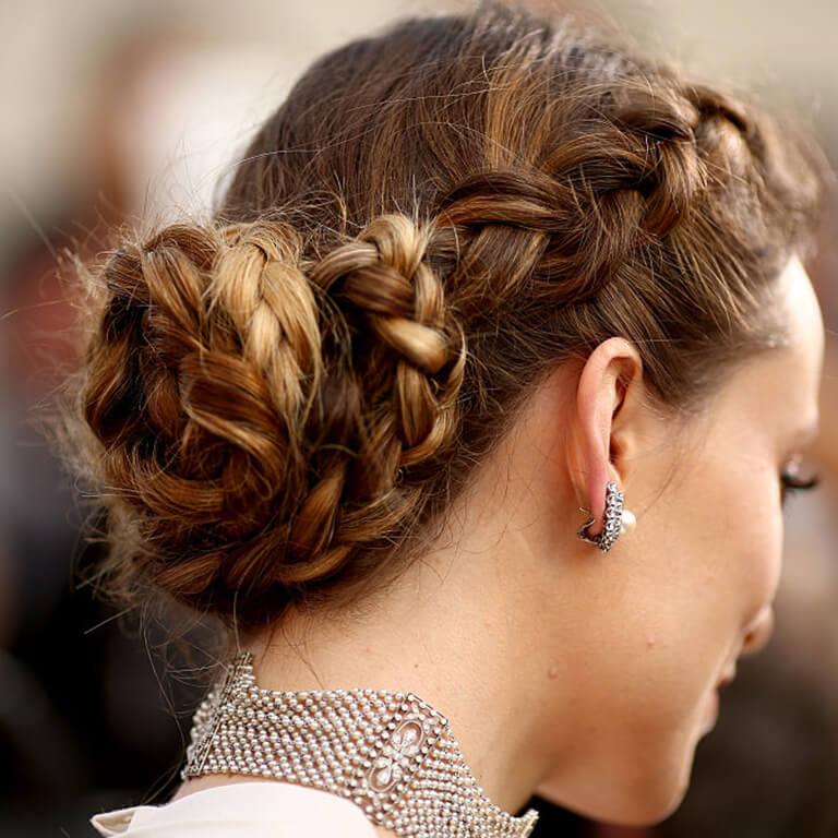 A close-up image of Olivia Wilde's Boho braided bun hairstyle