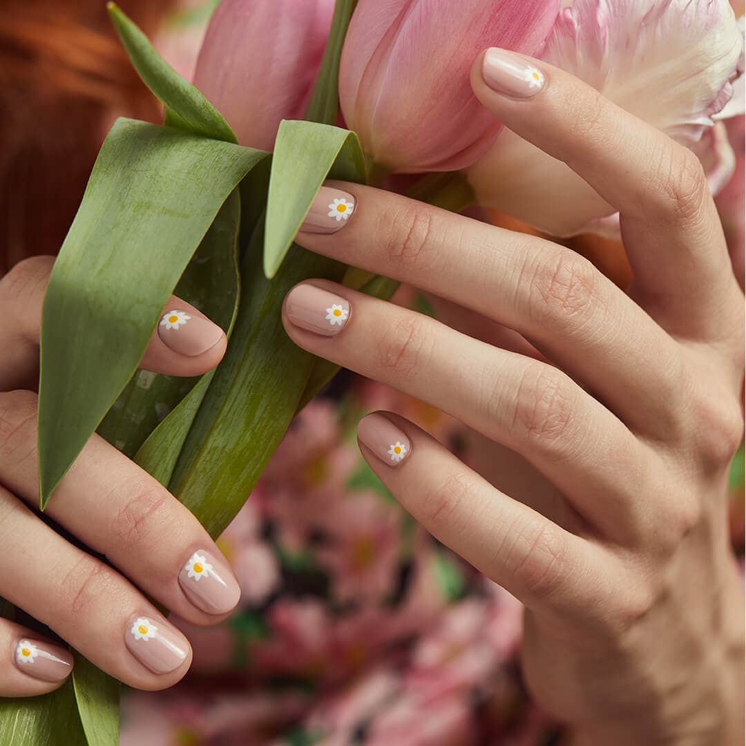 Close-up of model's hands with daisies nail art holding flowers