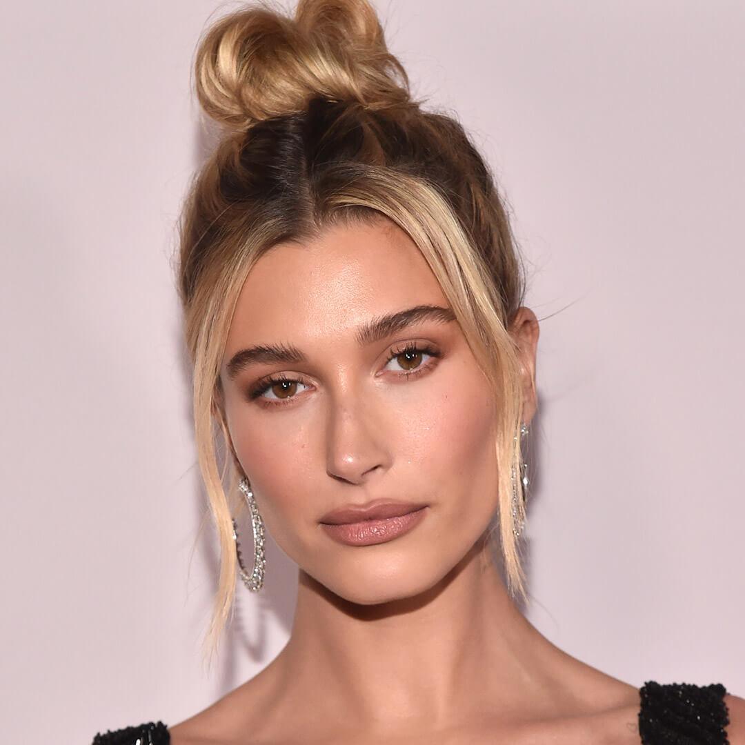 A photo of Hailey Bieber with blonde hair and a messy bun