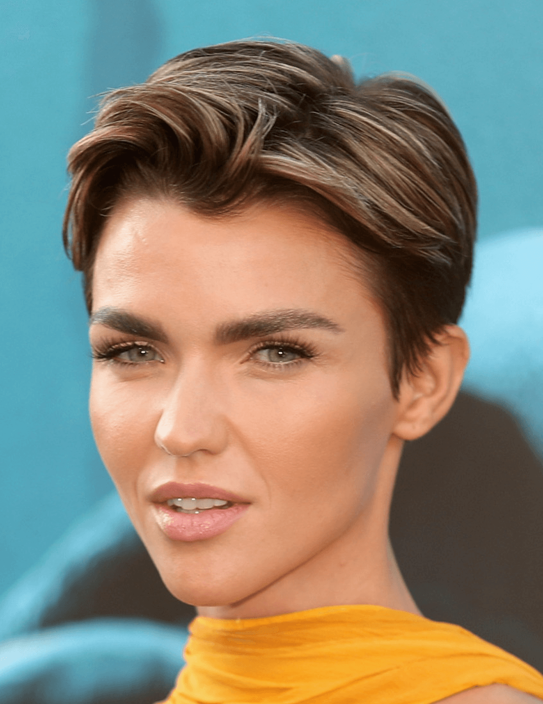 Ruby Rose in a yellow dress rocking a boy band cut hairstyle