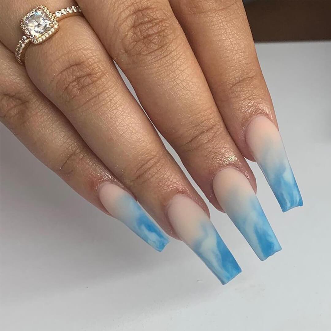 Close-up of woman's hand with blue marble ombré nail art
