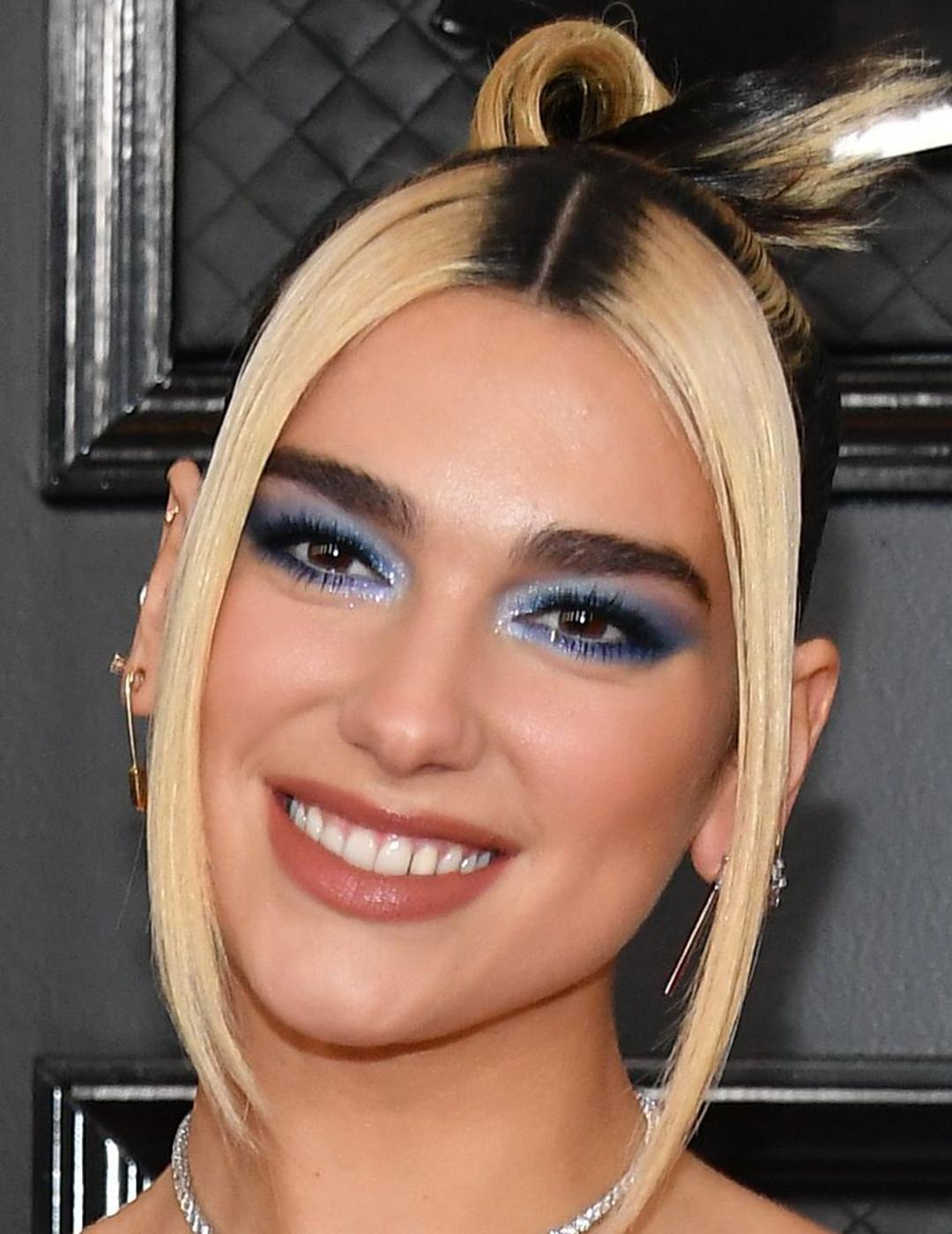 A photo of Dua Lipa looking fab with blonde hair and rooted streaks