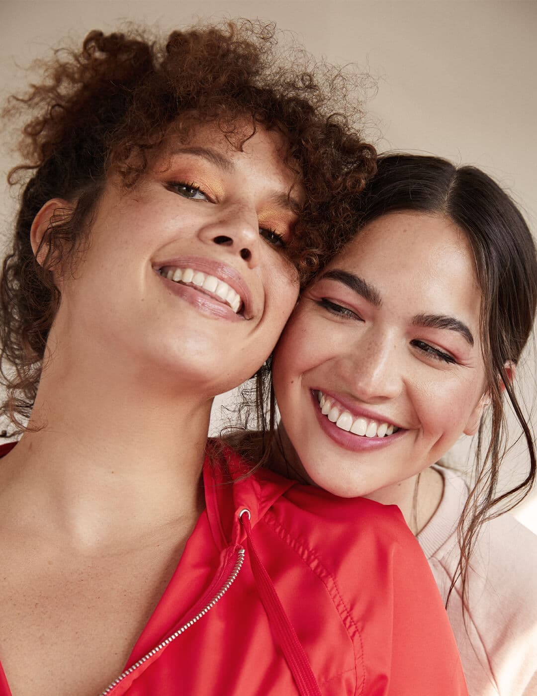 An image of two models with different hair types smiling.
