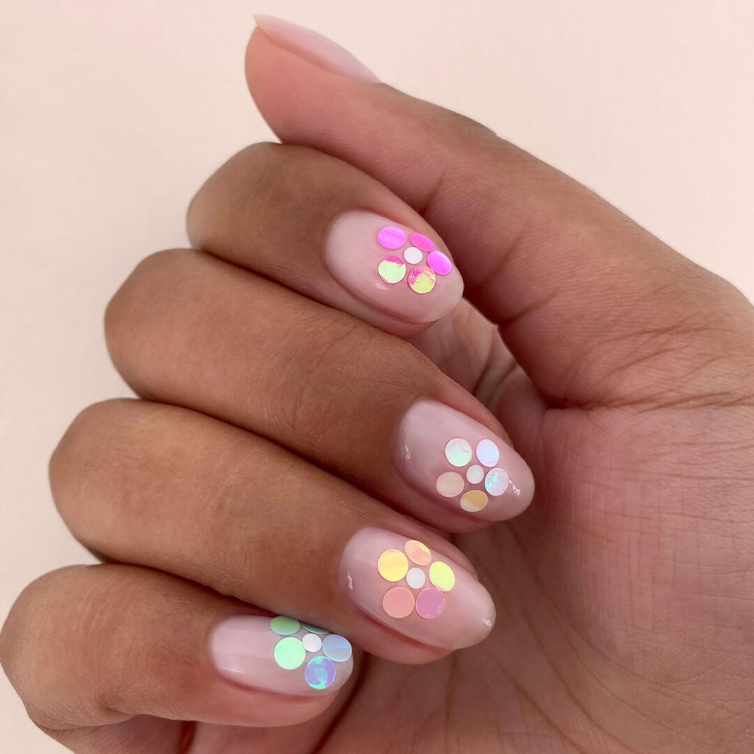 Close-up image of hand with floral sequins nail art