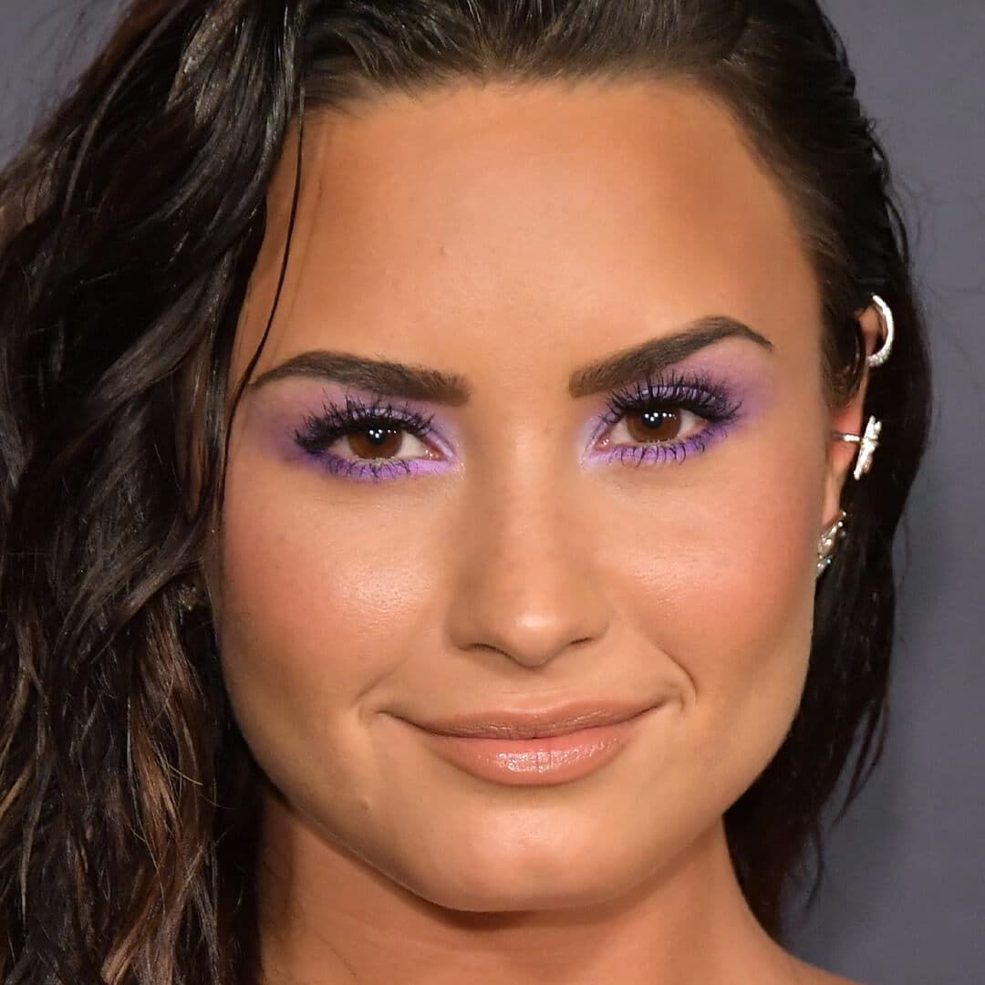 Close-up image of Demi Lovato rocking a purple eyeshadow look and bold lashes