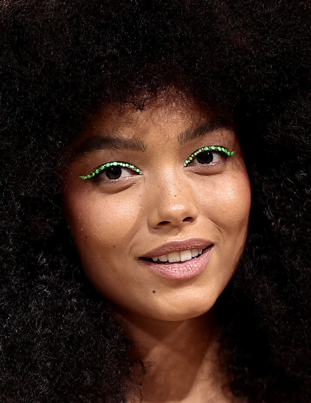 Whitney Peak rocking afro hair and a neon green eyeliner makeup look on the red carpet