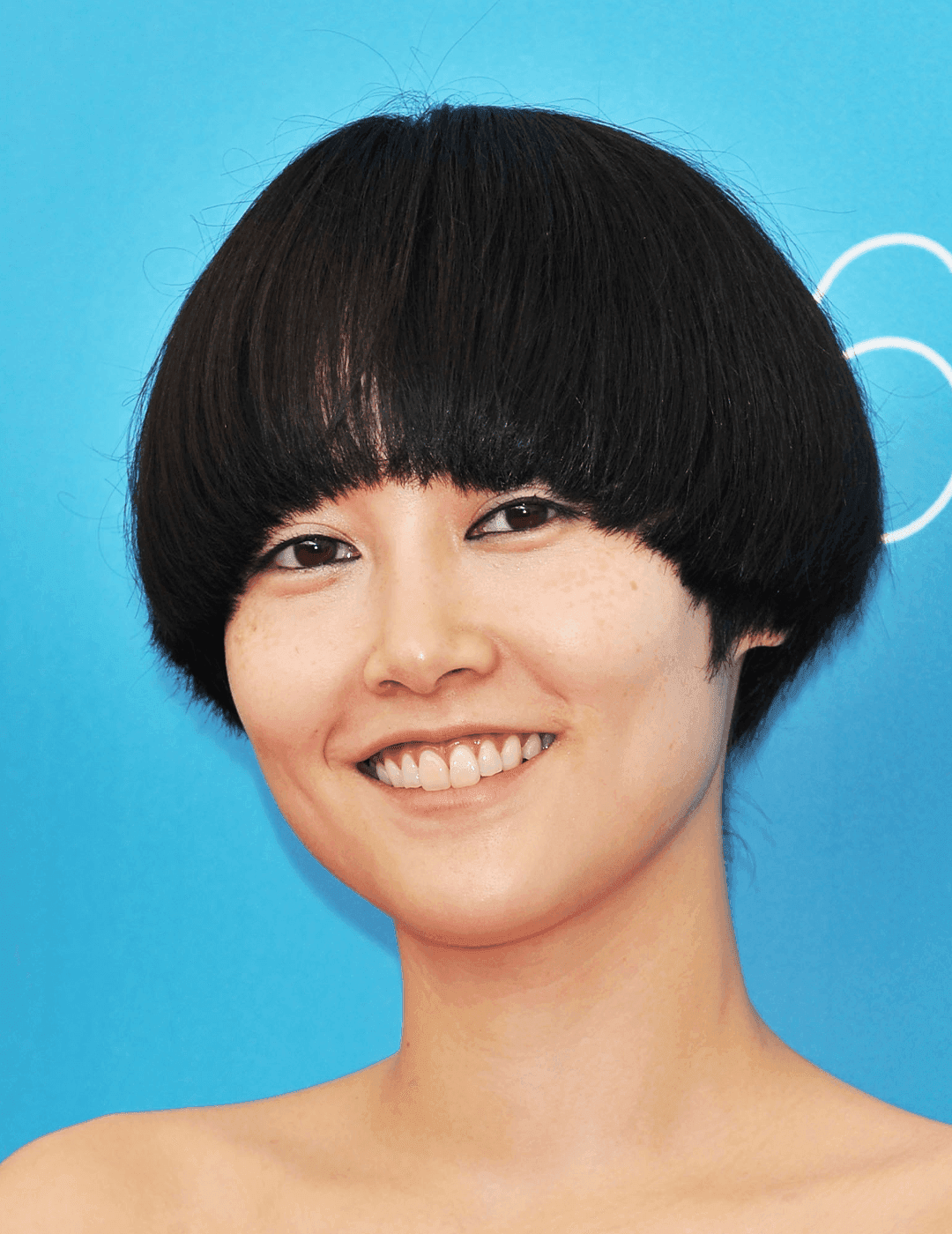 Smiling Rinko Kikuchi rocking a mushroom cut hairstyle