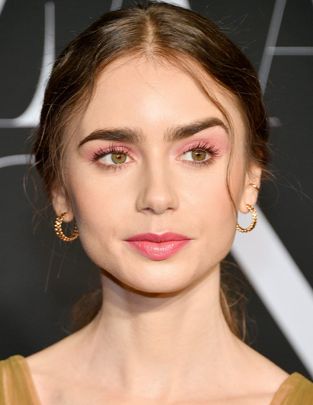 Lily Collins rocking a pink monochromatic makeup look and mustard dress on the red carpet