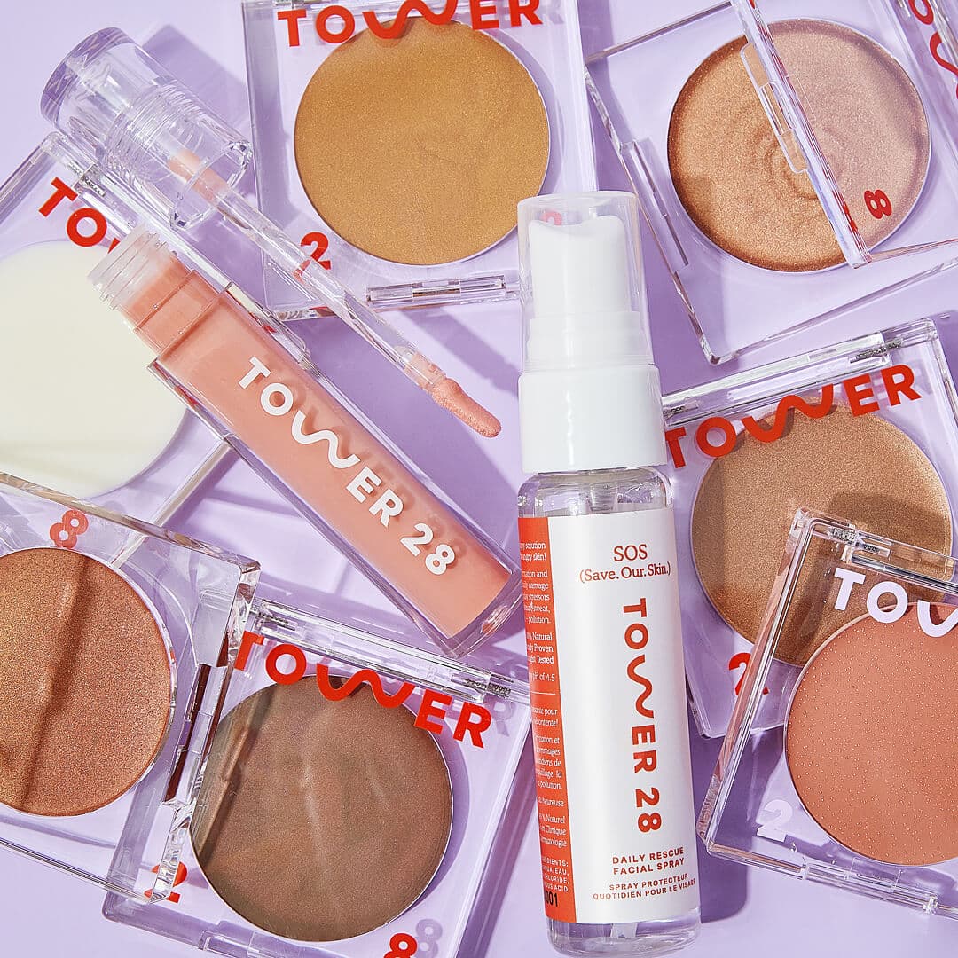 Makeup and beauty products from TOWER 28 on lavender background