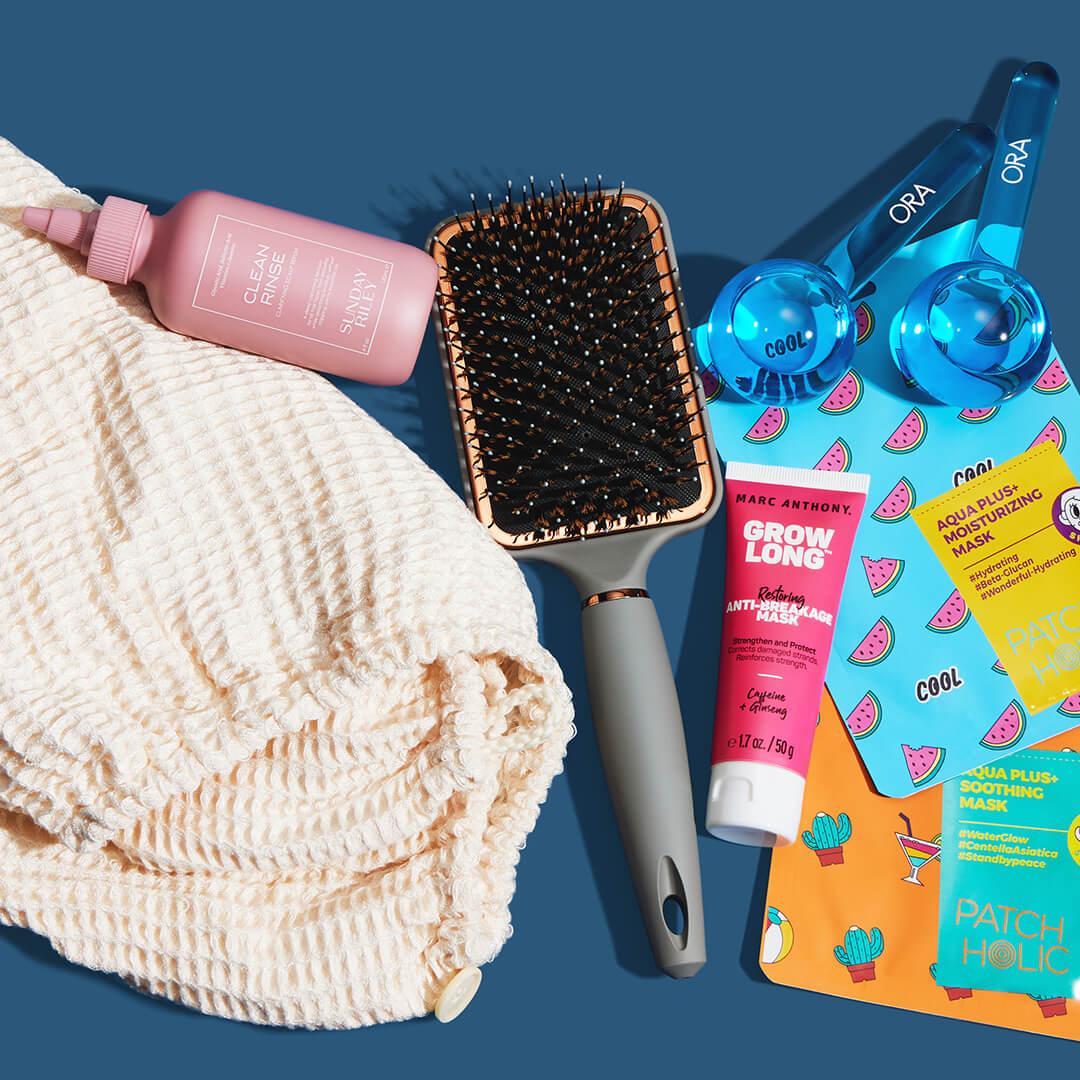 Beauty, skincare, and hair care products and tools from various brands on dark blue background
