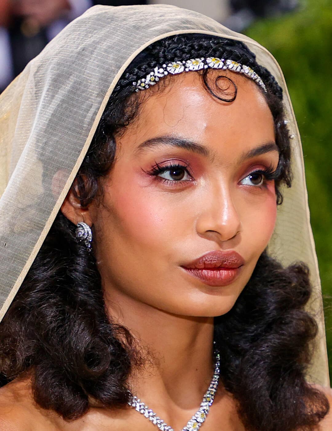 Yara Shahidi rocking a Gatsby-inspired makeup look, silver jewelry, and cream veil on the red carpet