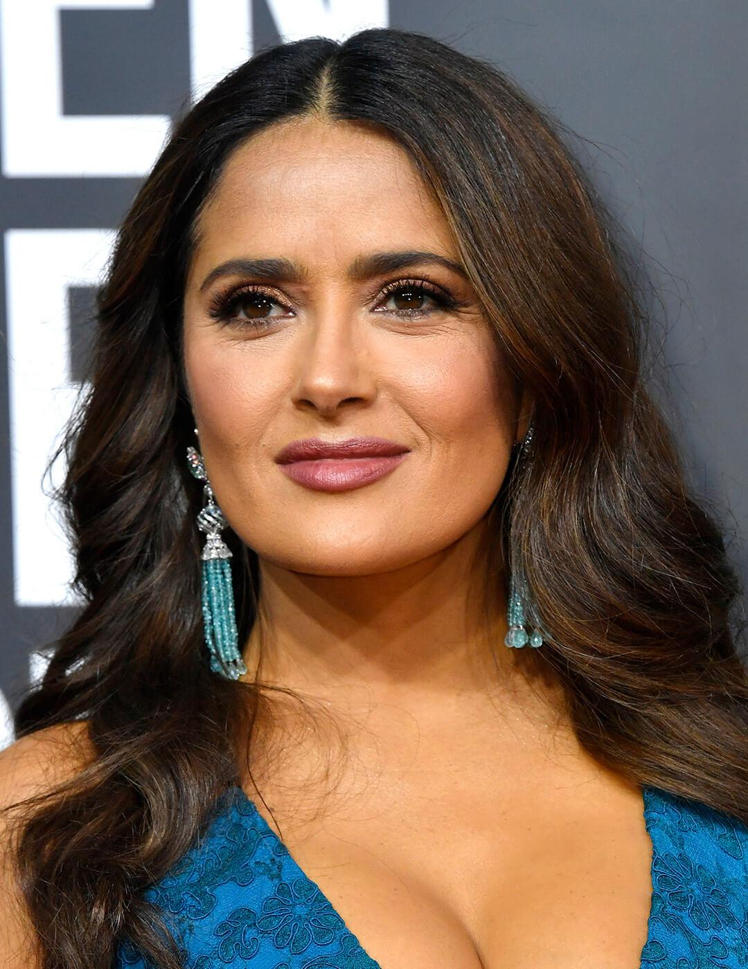 A photo of Salma Hayek with loose wave hairstyle wearing a blue dress 