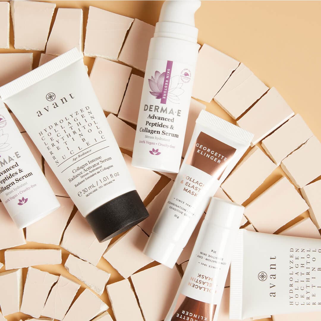 Collagen-based skincare products on top of tiny cream cardboard boxes against dark cream background