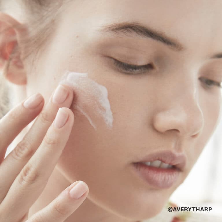 A model slathers on a moisturizer to keep her skin hydrated. 