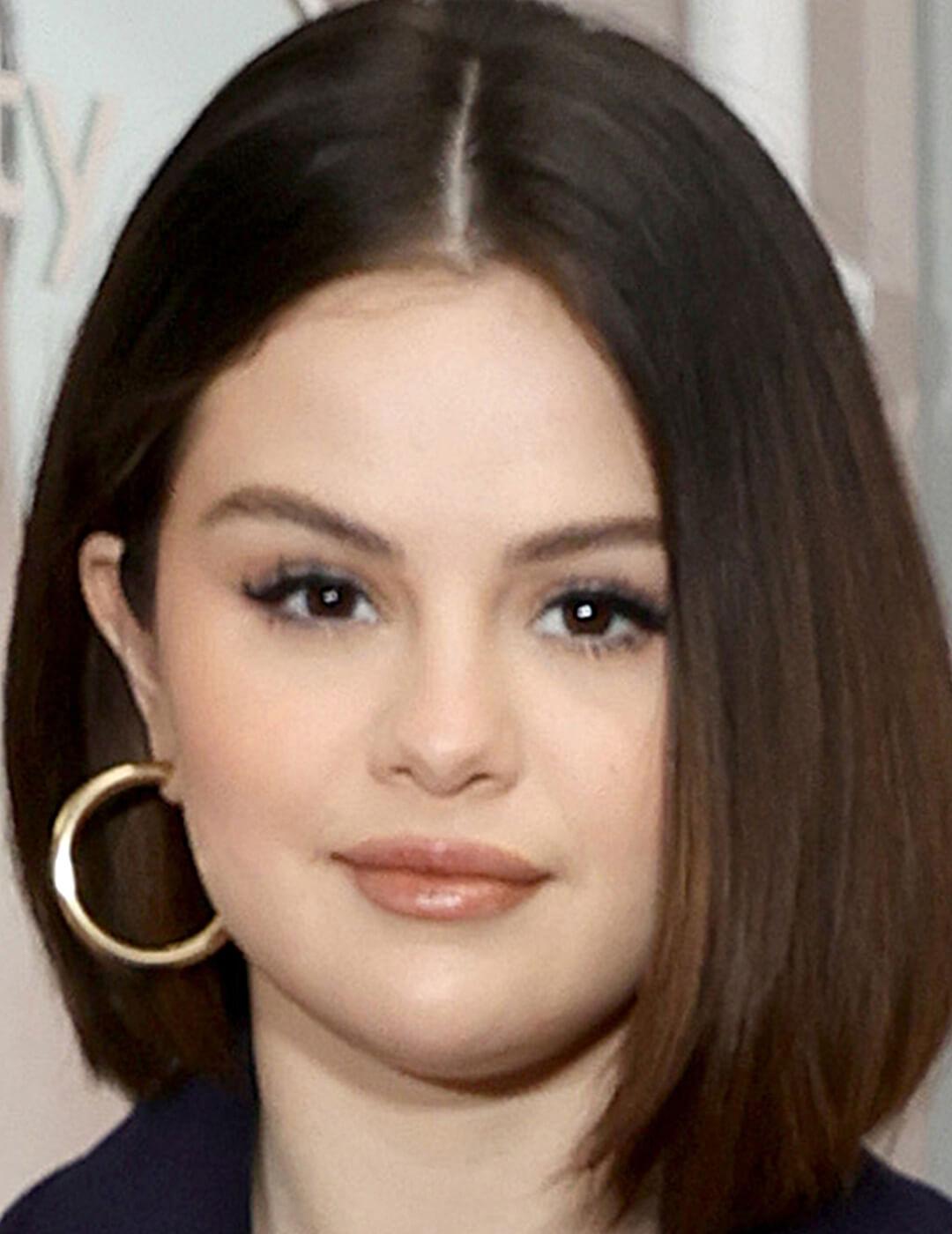 Selena Gomez rocking a natural makeup look, bob hairstyle, and gold hoop earrings