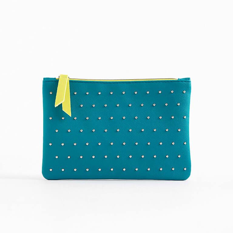 The March 2020 Glam Bag is blue-green with silver studs and neon yellow zipper tab