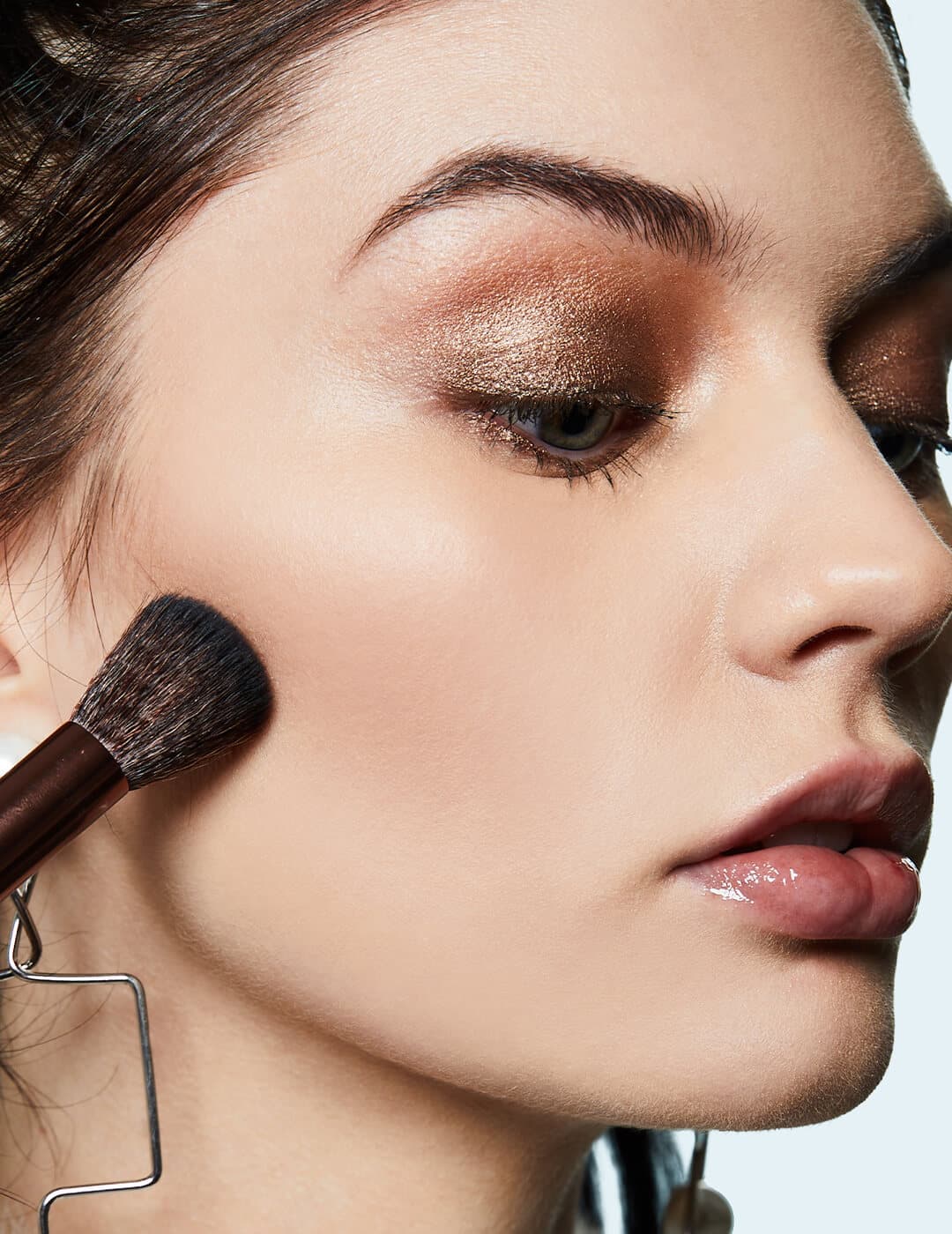 Close-up of a model applying contour below her cheeks