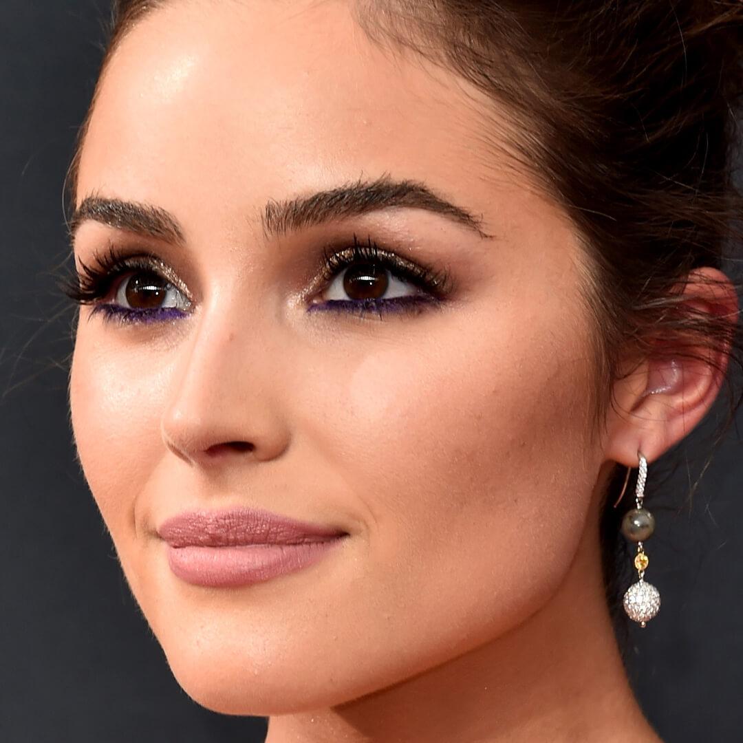 Close-up image of Olivia Culpo rocking a purple eyeliner look and bold lashes