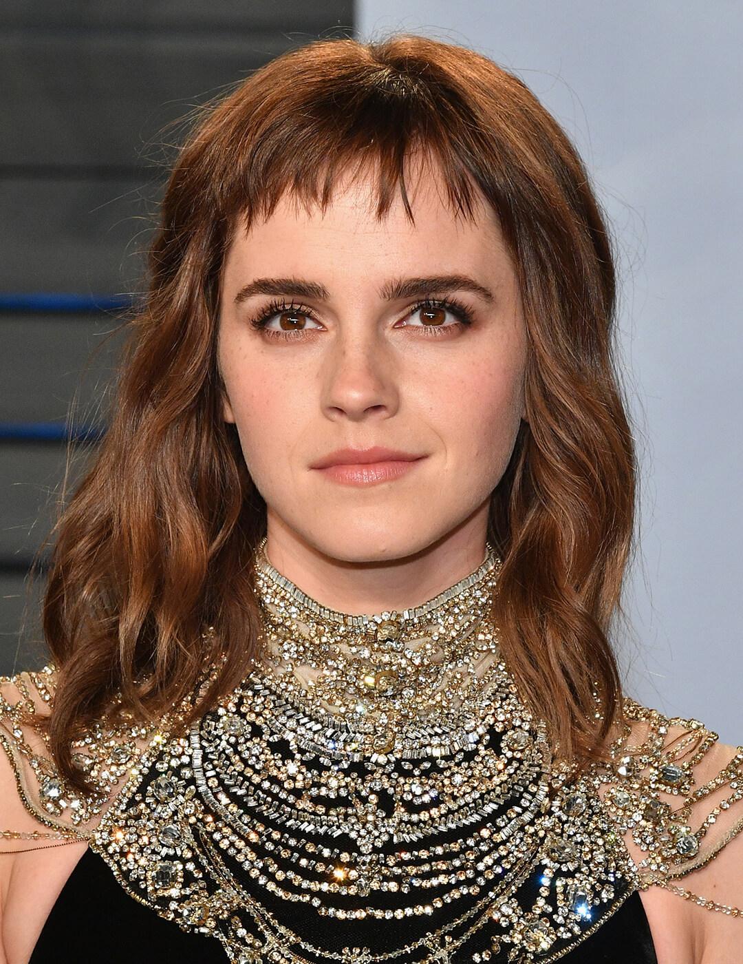 Emma Watson rocking beach waves with micro bangs hairstyle and neutral makeup look