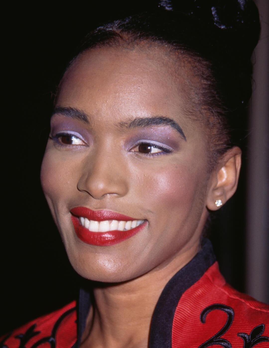 Younger Angela Basset rocking purple eyeshadow and bright red lips