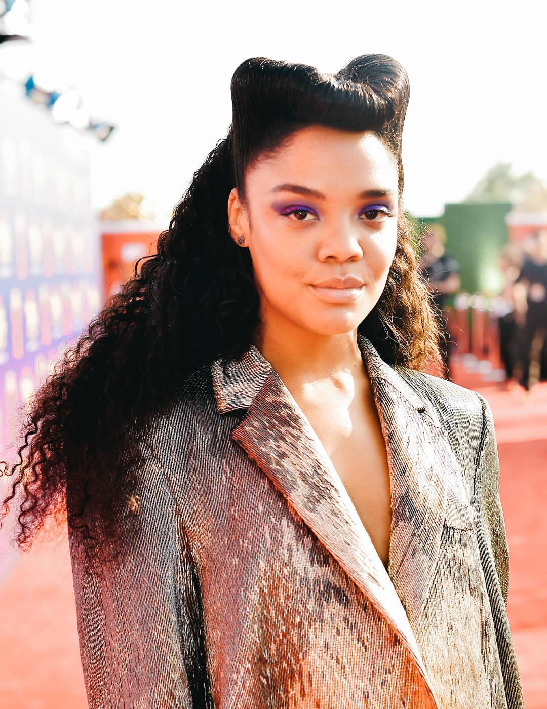 Tessa Thompson rocking a retro roll hairtyle in textured suit