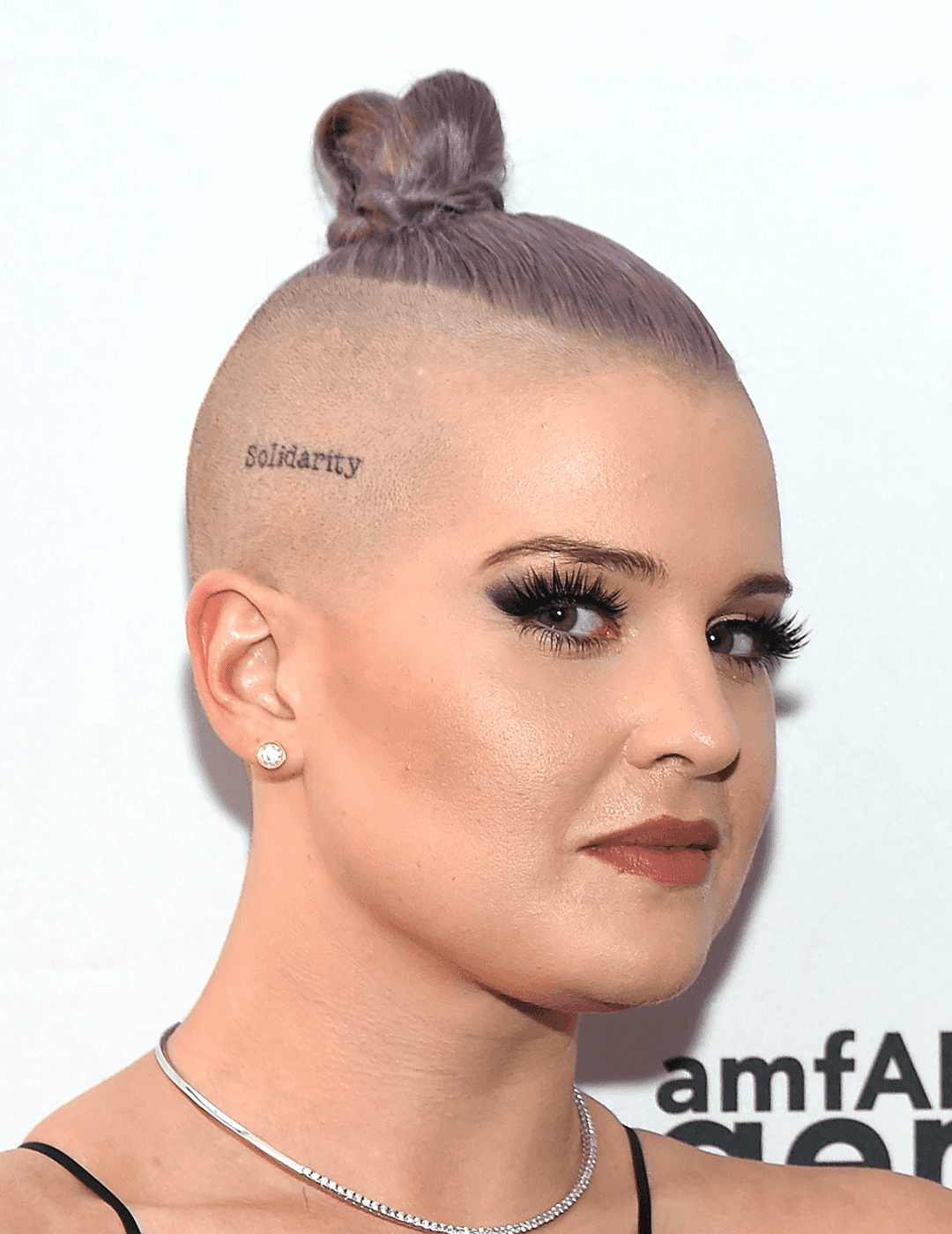 Kelly Osbourne with a lavender undercut with top knot hairstyle side-eyeing