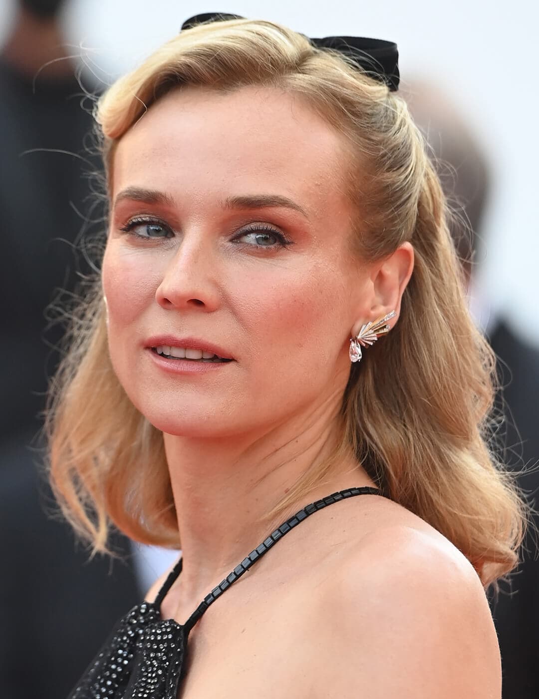 Diane Kruger rocking a retro-inspired half updo hairstyle with matching black velvet bow at the red carpet