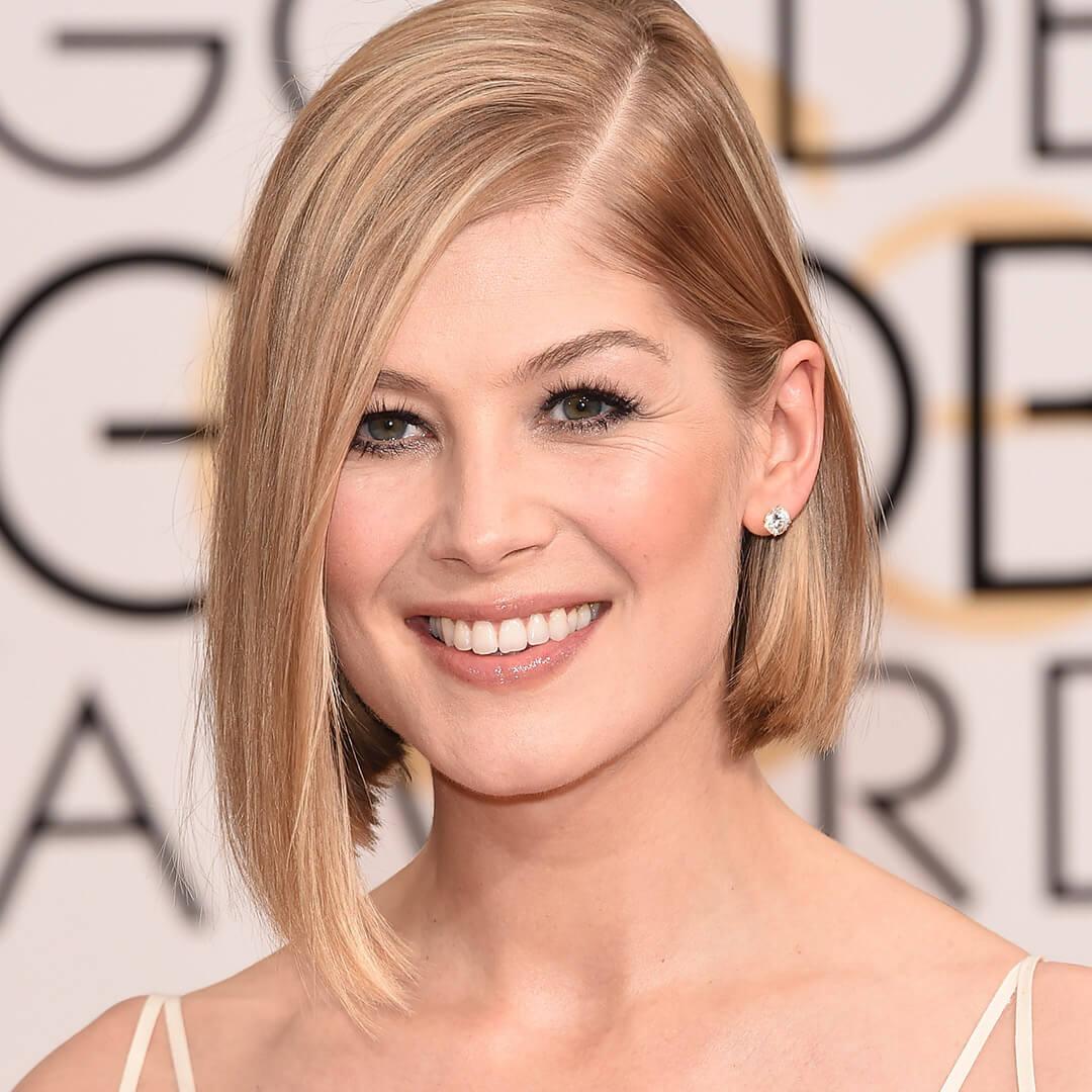 Smiling Rosamund Pike rocking a side parted bob hairstyle