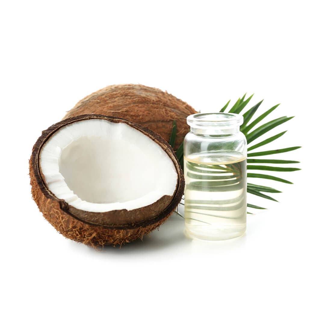 Image of coconut halves and a bottle of coconut oil on white background