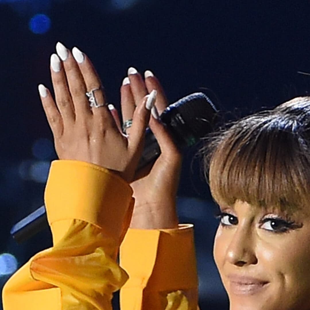 Close-up of Ariana Grande's hands with nail mani holding a microphone