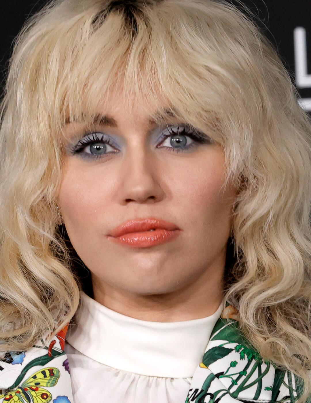 Miley Cyrus rocking pastel blue eyeshadow and warm peach lipstick on the red carpet