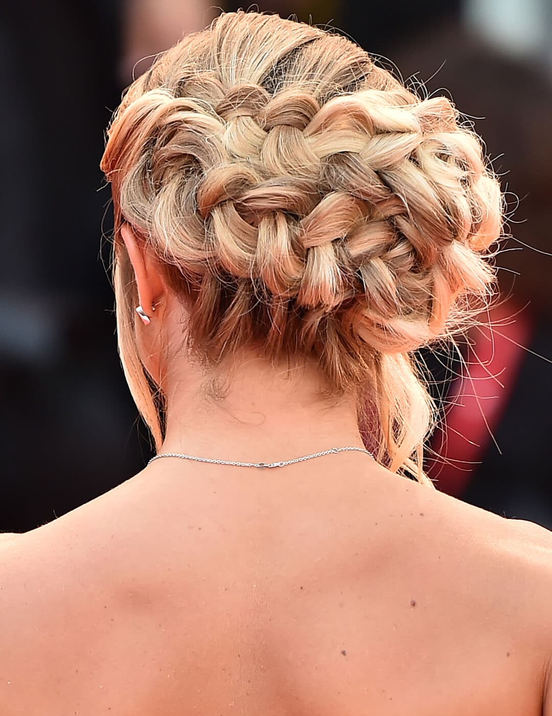 Anna Penello facing back showing off her braided updo hairstyle