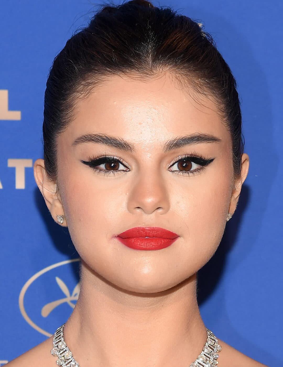 Selena Gomez rocking a cat eyeliner makeup look paired with red lips