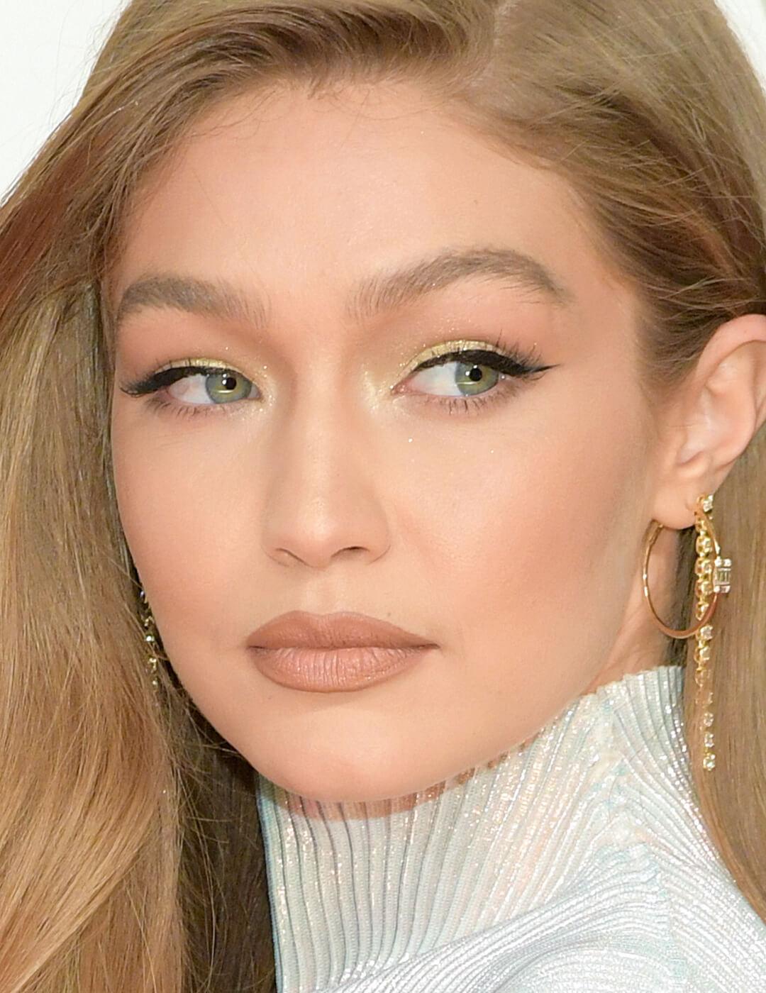 Close-up of Gigi Hadid rocking a neutral makeup look accented with gold eye shadow