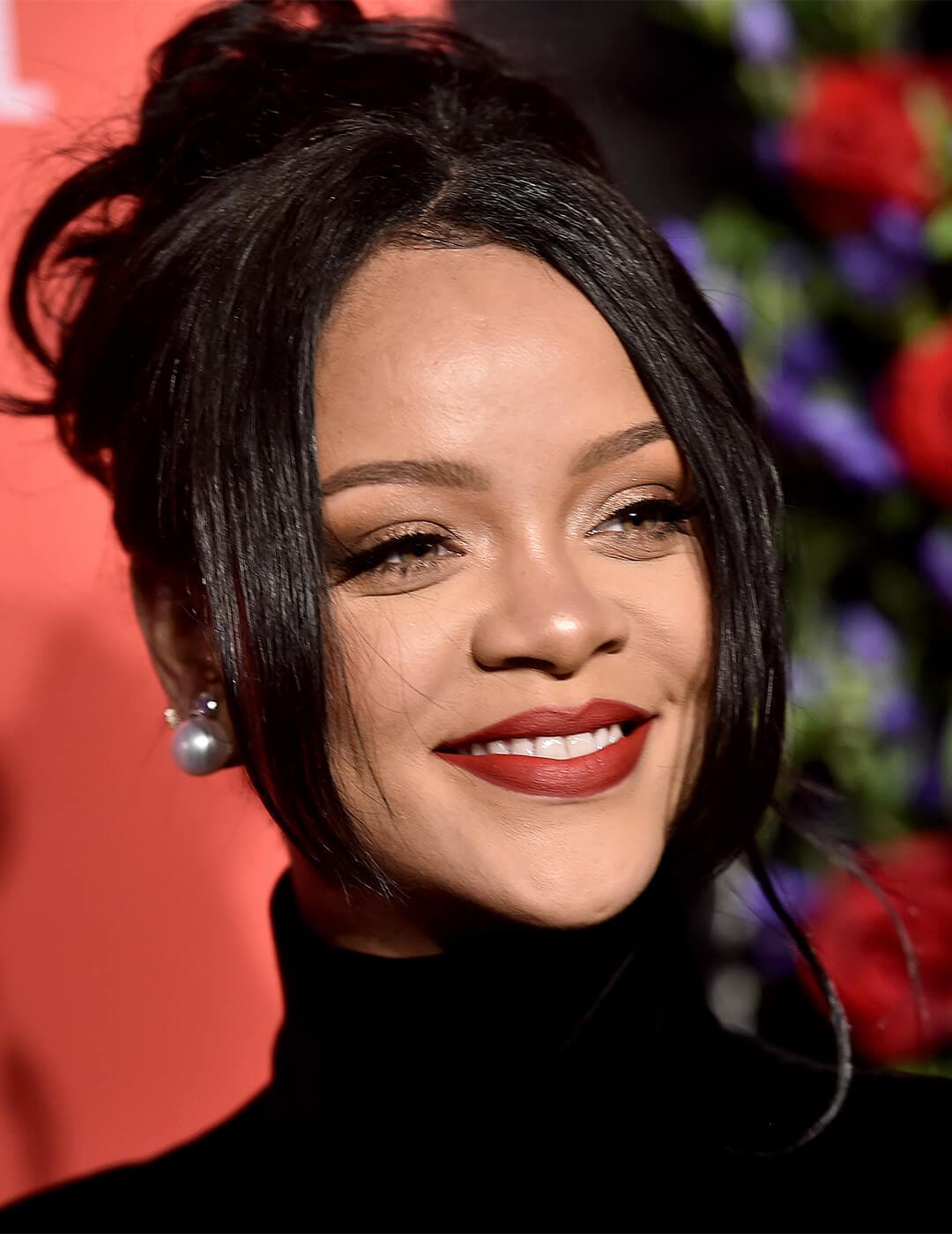 Rihanna rocking a '90s-themed messy bun hairstyle and black turtleneck top at the red carpet