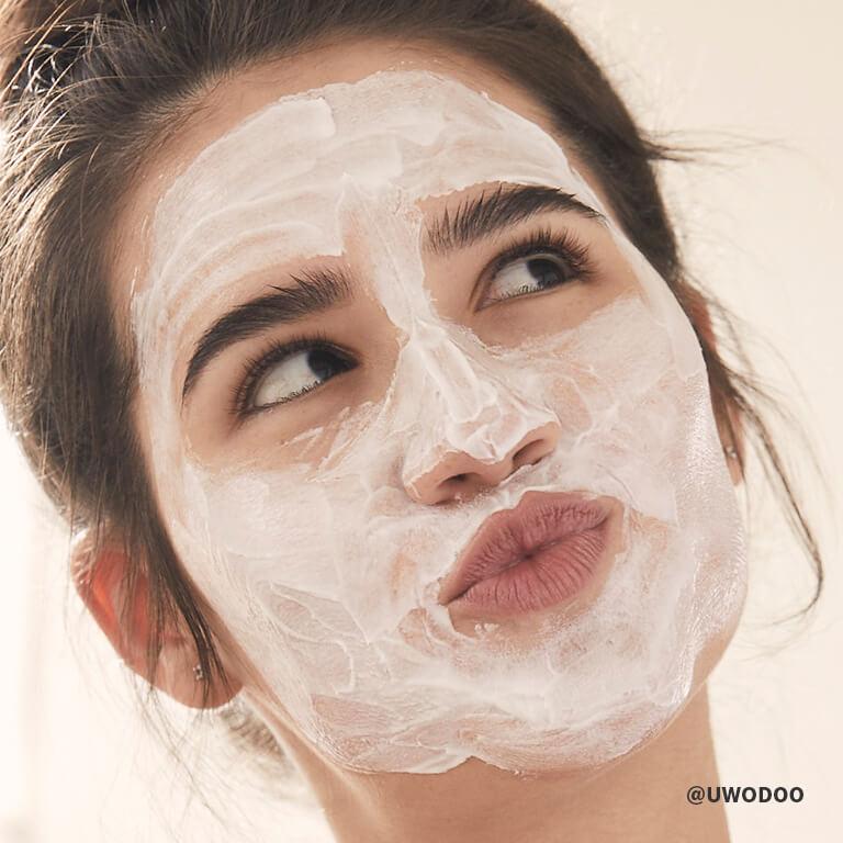 A model having face mask on purses her lips