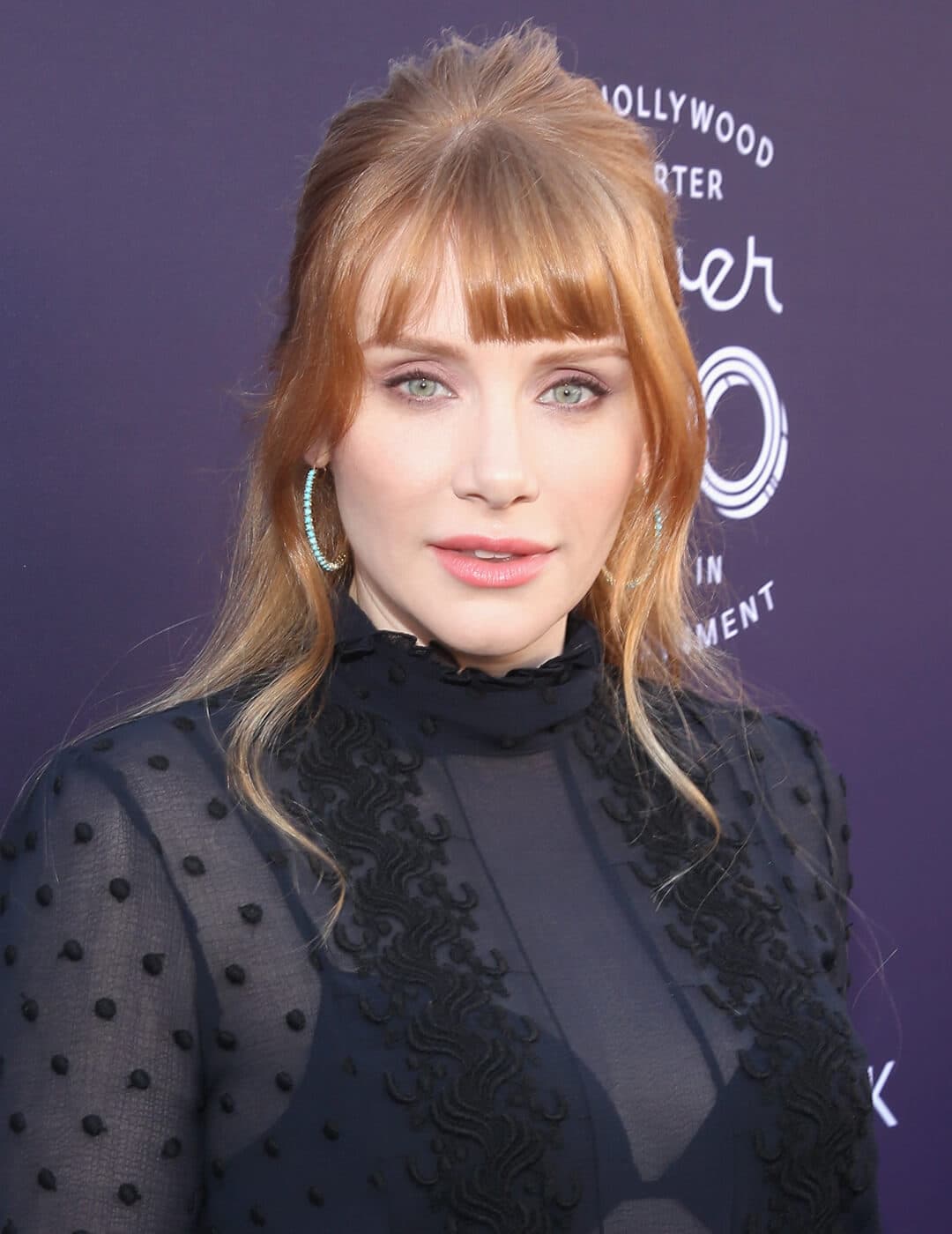 A photo of Bryce Dallas Howard with golden blonde hair and a light copper shade, wearing 
