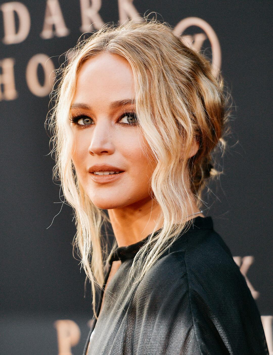 Jennifer Lawrence looking chic in a messy, low bun hairstyle and black outfit